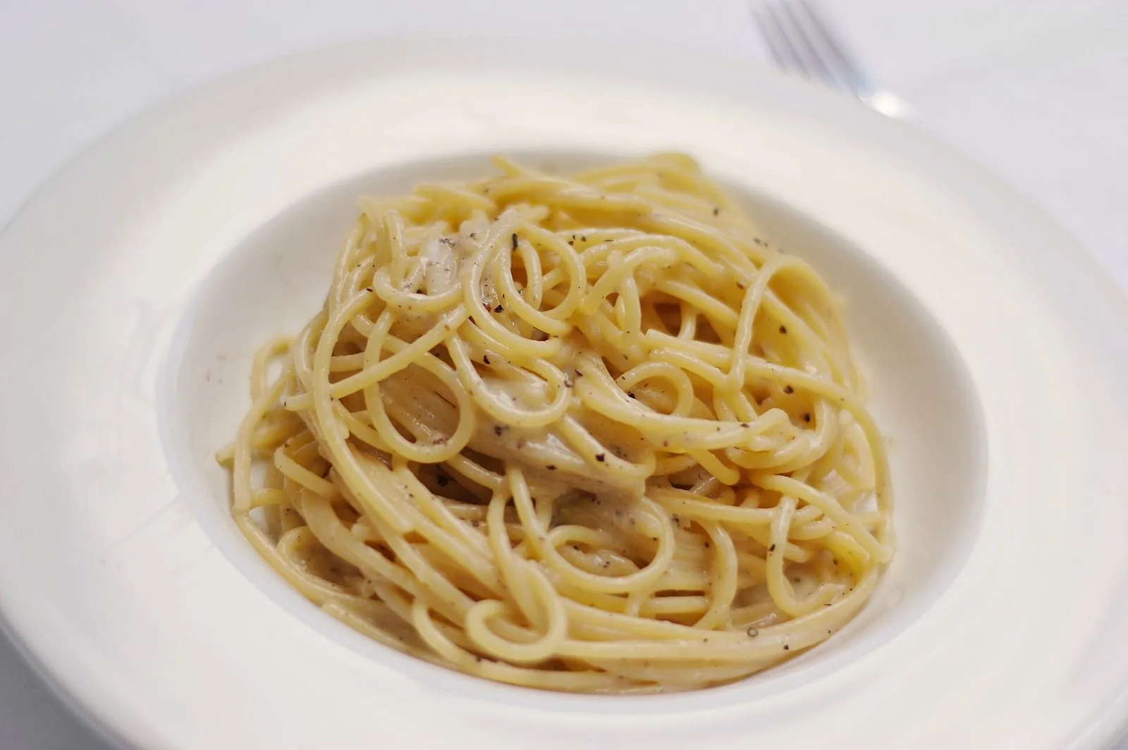 Un piatto di spaghetti cacio e pepe, pasta romana con pecorino e pepe nero